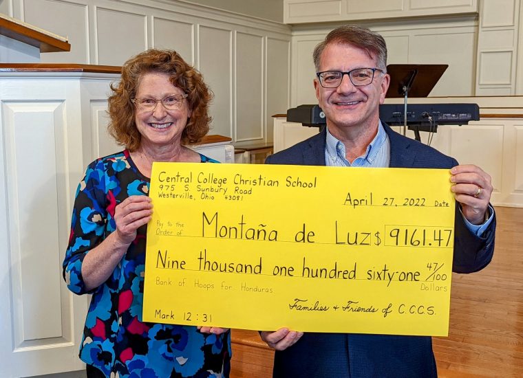 Central College Christian School teacher Mary Townley presents Montaña de Luz board president Doug Haddix with a check for more than $9,100 to help children and families affected by HIV/AIDS in Honduras.