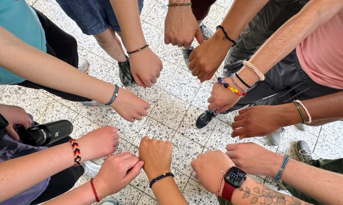 Children receiving care at Montaña de Luz in Honduras form a circle of outstretched arms with volunteers